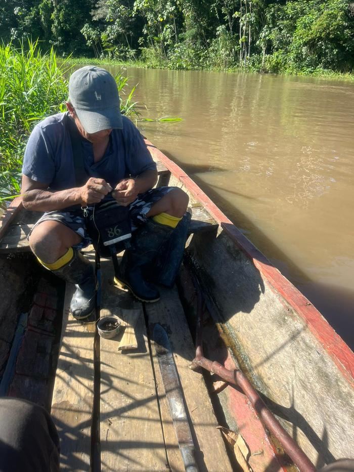 Un guide prépare sa ligne de pêche à l'avant de la pirogue