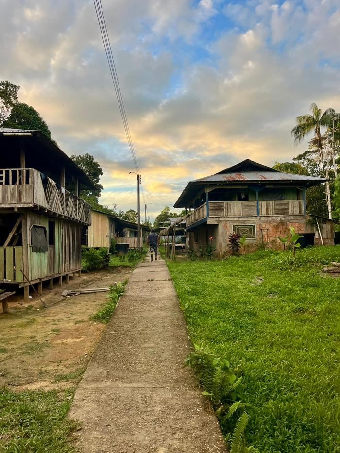 La rue du village au coucher du soleil, maisons de bois sur pilotis